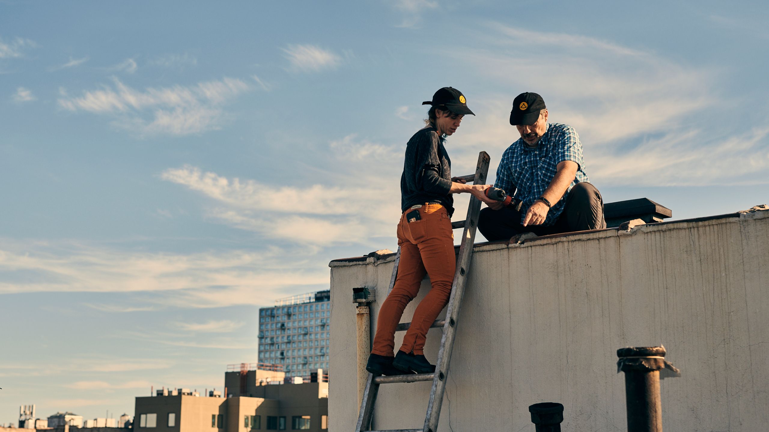 Two people instal WiFi nodes on a rooftop