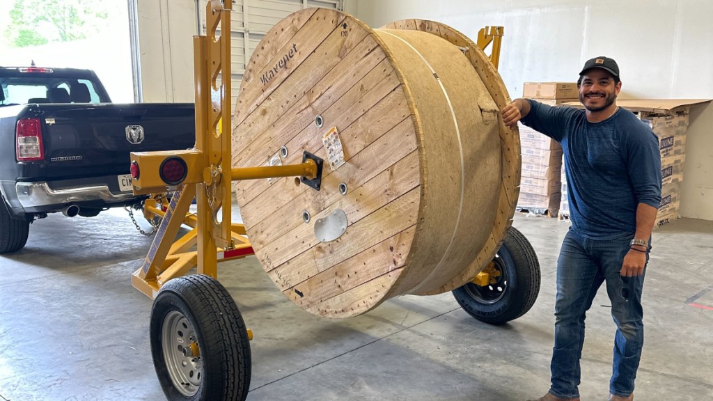 Photograph of Juan Castilla, Hawk Networks Construction Manager in Atlanta, with reel of fiber.
