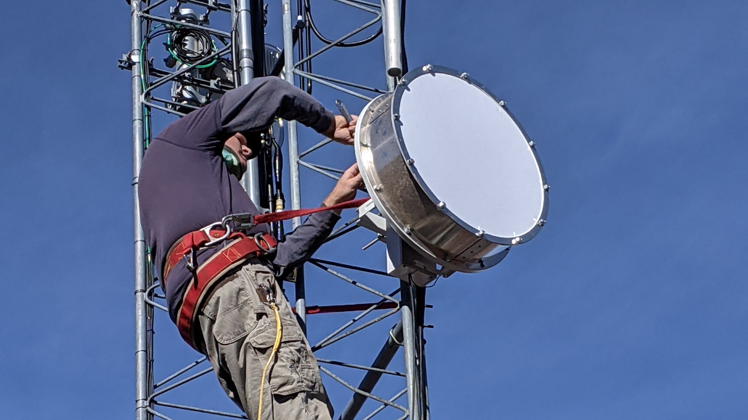 Photograph of Jim Kossow working on a communications tower
