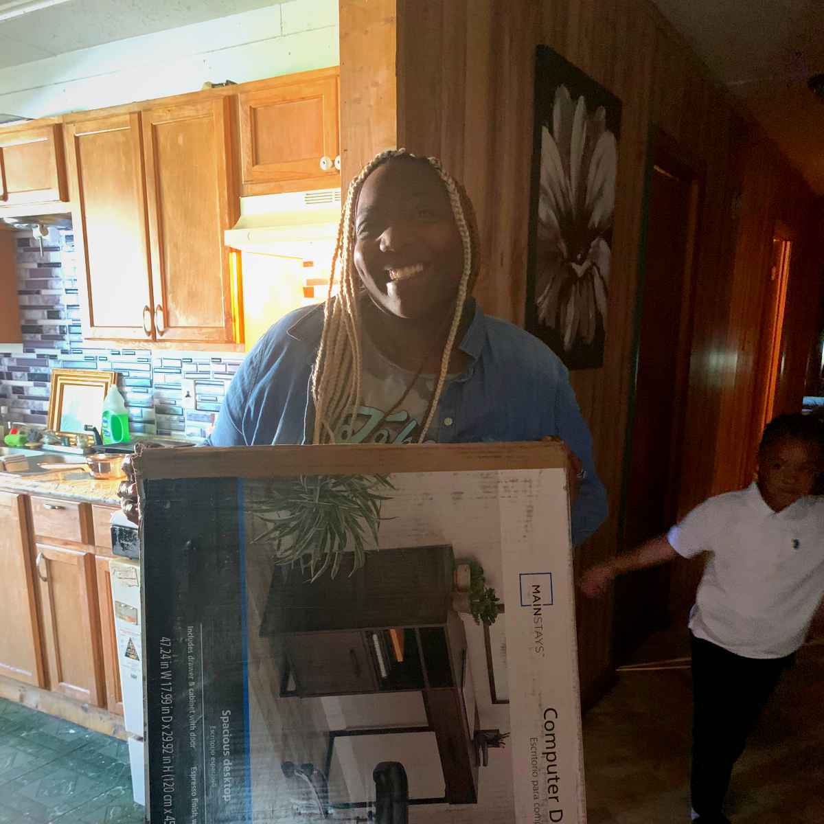 Latanya Gray Swift, holding her new desk for her remote job