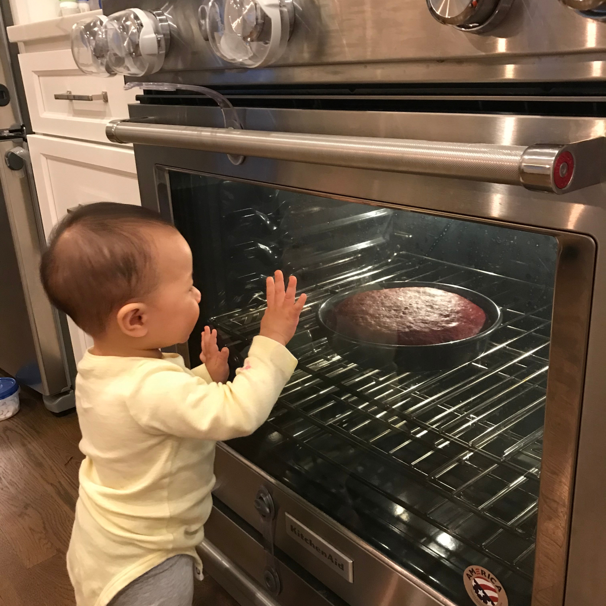 Brian's child looks at cake baking in the oven 