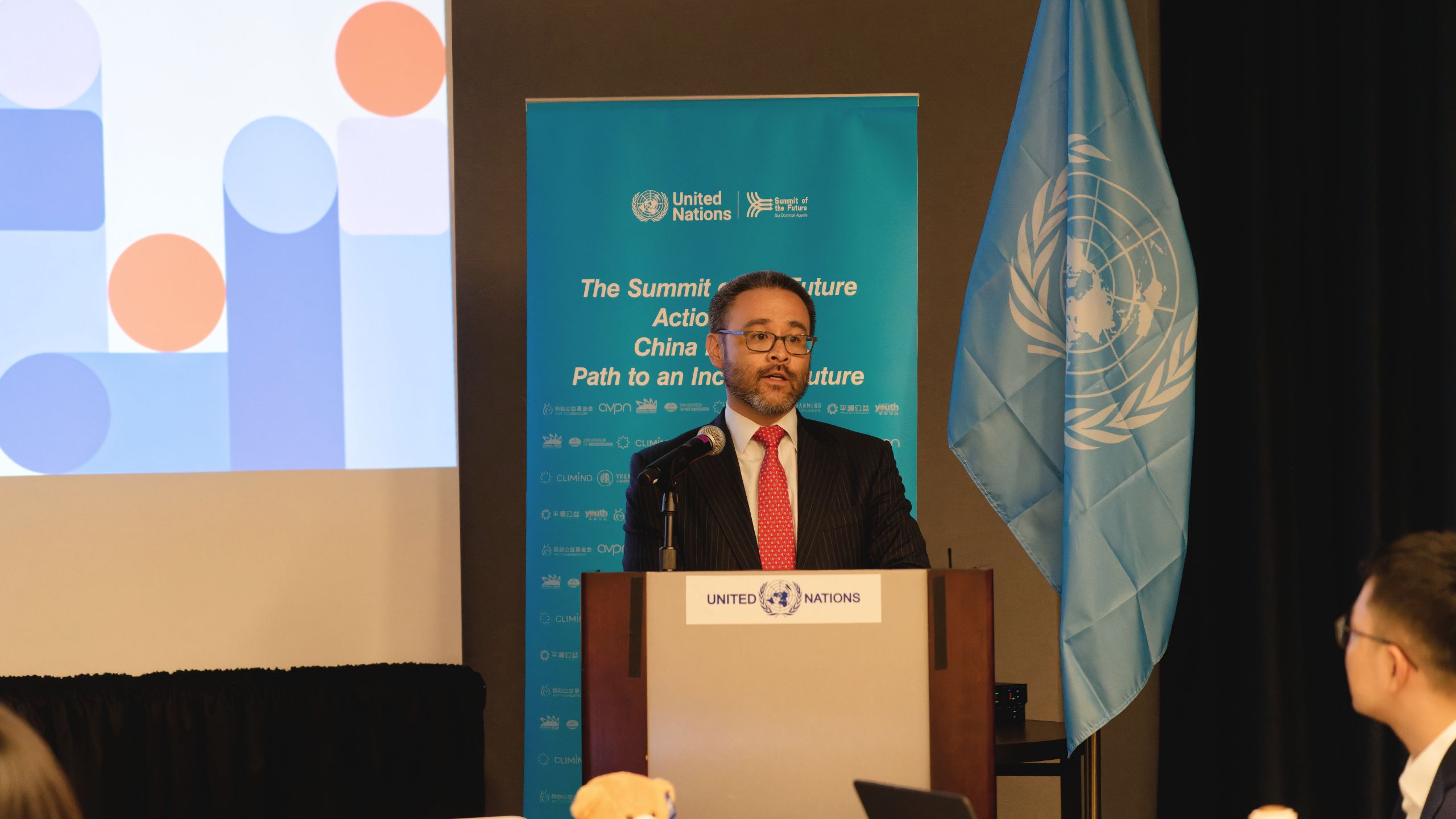 Photo of Brian Vo at podium by UN Flag