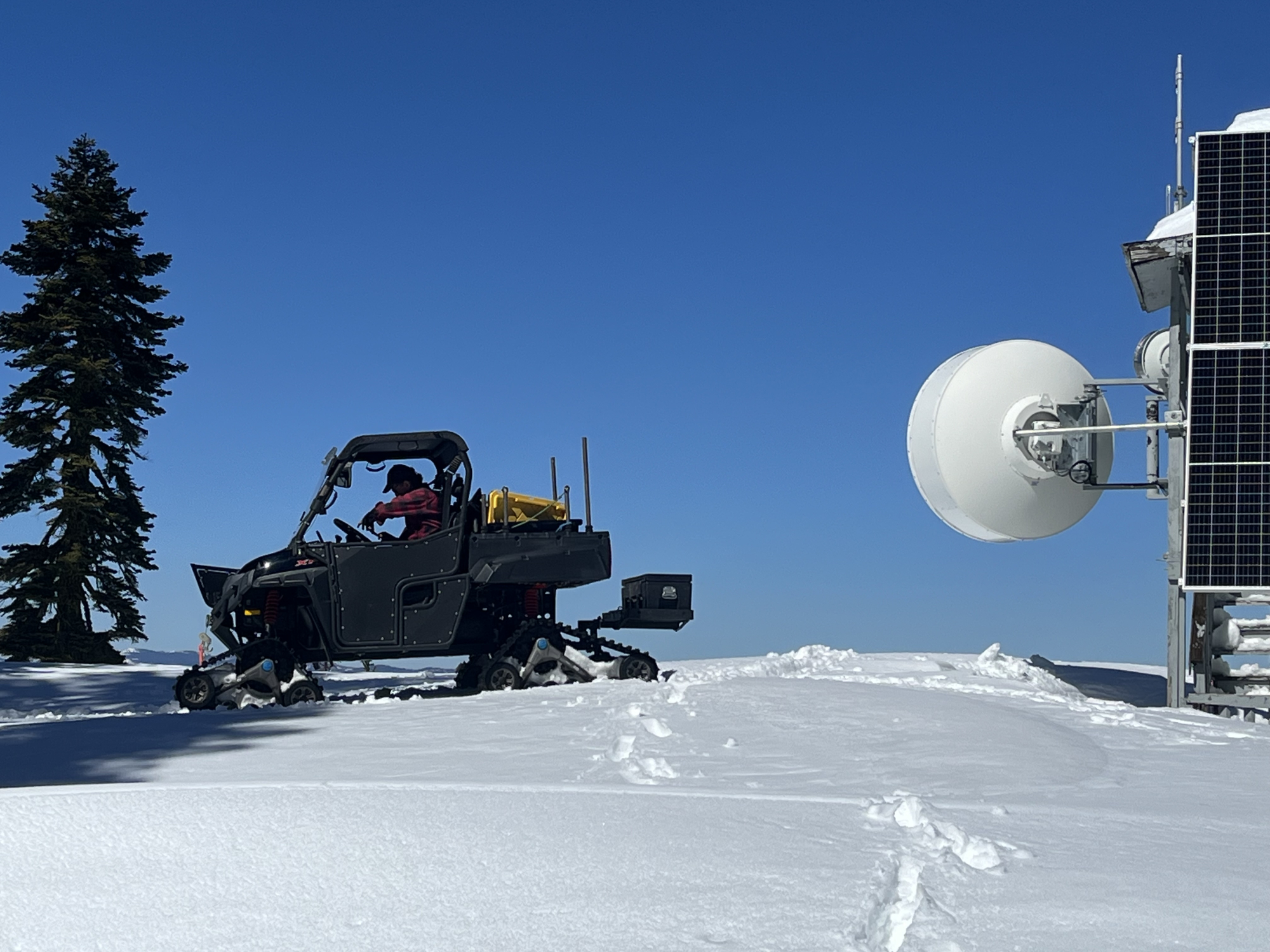 Man in Snowcat vehicle on mountaintop