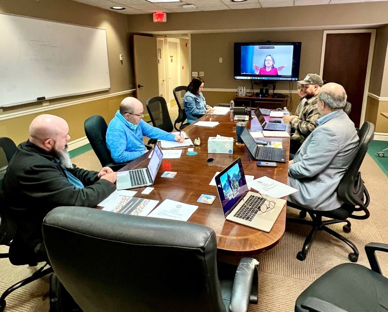 Photo of people standing around Red Bird Mission Campus sign